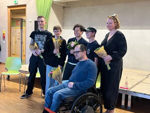 Gruppenfoto: 6 Personen. 4 Frauen, ein Mann links und ein Rollstuhfahrer vorn. Alle haben einen Strauß Blumen in der Hand.