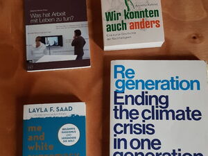Vier Bücher auf einem Tisch. 1. Was hat Arbeit mit Leben zu tun, 2. Wir konnten auch anders, 3. Warum kritisches Weißsein mit dir selbst anfängt und 4. Re-generation